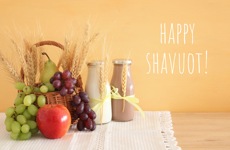 Image of milk and fruits over wooden table symbols of jewish holiday shavuot