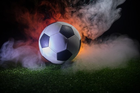 Traditional soccer ball on soccer field close up view of soccer ball football on green grass with dark toned foggy background selective focus Stock Photo