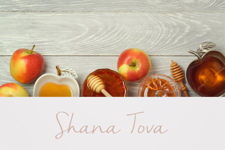 Jewish holiday rosh hashana creative background with honey and apples flat lay layout