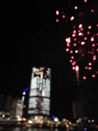 Defocused abstract scene of riverside firework in city center at night to celebrate festive event Stock Photo