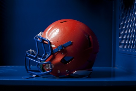 An american football helmet sits in an empty locker dramatic lighting