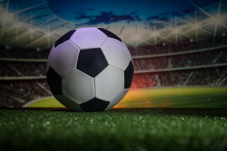 Traditional soccer ball on soccer field close up view of soccer ball football on green grass and stadium on background selective focus