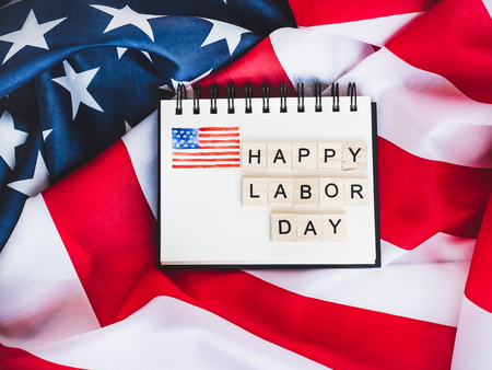 Notepad with blank page wooden letters of the alphabet in the form of the words labor day on the background of the us flag top view close up Stock Photo