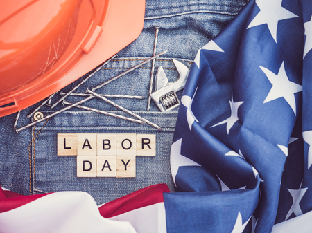 Usa flag tools and wooden letters with the inscription labor day on the background of a blue jeans pocket top view close up preparation for the celebration of labor day Stock Photo