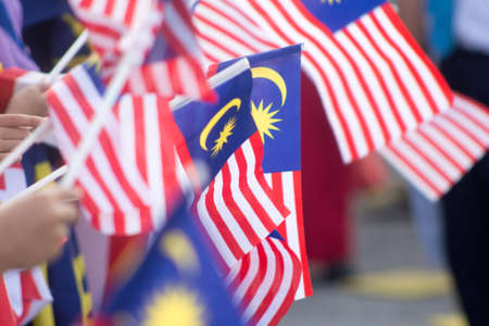 Hand waving malaysia flag also known as jalur gemilang in conjunction with the independence day celebration or merdeka day