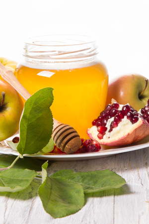 Pieces ripe pomegranate honey and apple on a white background