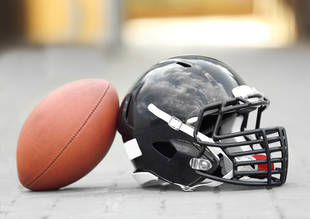 Rugby helmet with ball on ground Stock Photo