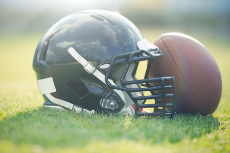 Rugby helmet with ball on field