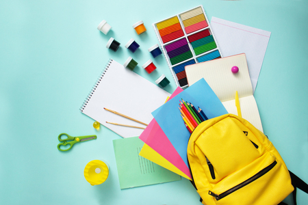 School stationary sets and knapsack on blue background top view