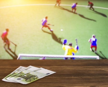 Euro money on the background of a tv on which show hockey on the grass sports betting euro Stock Photo