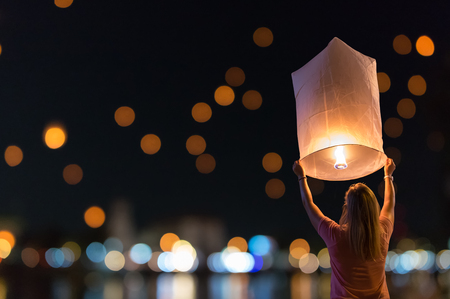 Women are releasing floating lanterns in the loy krathong festival or floating lanterns festival in chiang mai thailand