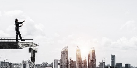 Businessman walking blindfolded on concrete bridge with huge gap as symbol of hidden threats and risks cityscape view with sunlight on background 3d rendering