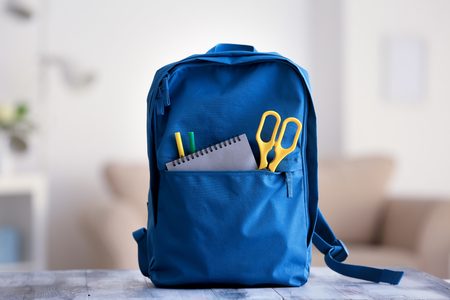 Backpack with school supplies on table Stock Photo