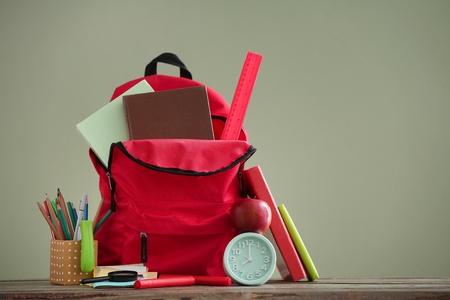 Backpack with school supplies on color background Stock Photo