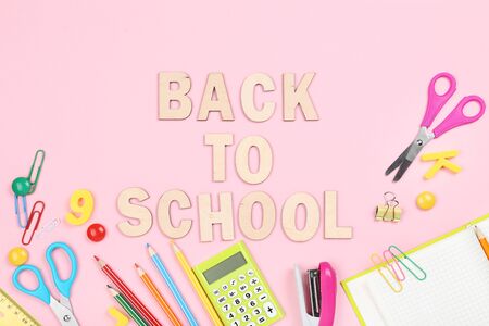 Text back to school with stationery on pink background