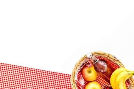 Basket with food picnic in summer with products fruits drinks and hat on white background top view space for text Stock Photo