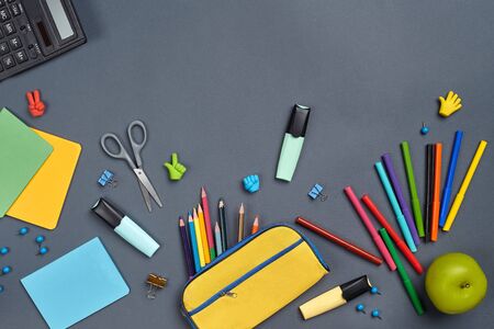 Flat lay photo of workspace desk with school accessories or office supplies on gray background