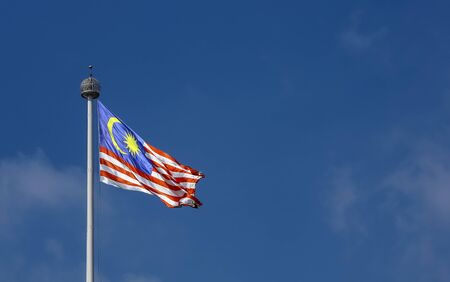 Malaysia flag also known as jalur gemilang waving with the blue sky background in conjunction of independence day or merdeka day celebration on 31 august and hari malaysia on 16 september