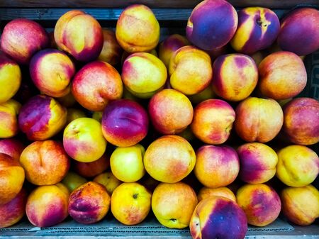 Background of ripe nectarines in the market ripe fruits on the counter m Stock Photo