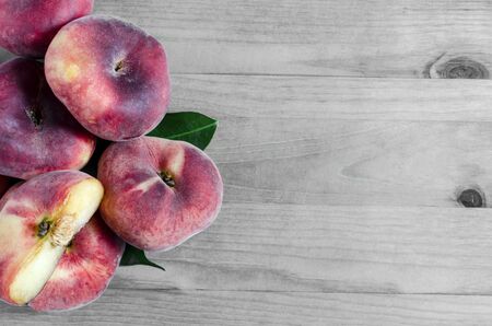 Flat peaches on a black and white backdrop of lush fig peaches copy space