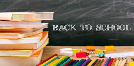 Classroom with stack books on table have blackboard and chalkboard on background back to school concept