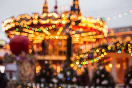 Blurred photo of christmas carousel at the fair near gum shop on red square in moscow russia