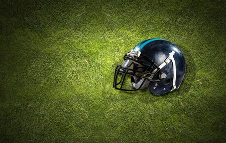 Rugby game helmet on green grass background