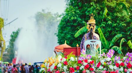 Beautiful with traditionally dressed woman is crowned to be miss songkran sit on pickup truck in parade on songkran festival in thailand