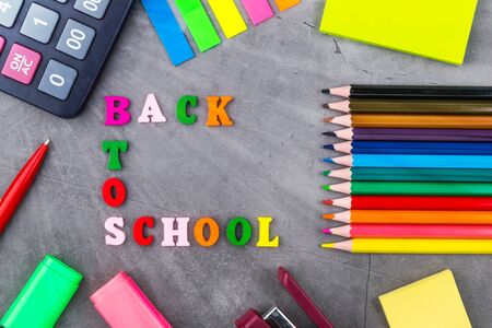 The layout of school supplies on a dark gray background top view the sun s rays from the side back to school flat lay Stock Photo