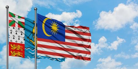 Saint pierre and miquelon and malaysia flag waving in the wind against white cloudy blue sky together diplomacy concept international relations Stock Photo