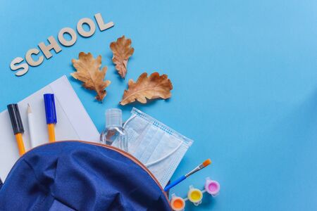 Study flatlay concept education supplies pencil pen brush paint medical mask and sanitizer paint on blue background back to school or kindergarten summertime creativity and learn background with