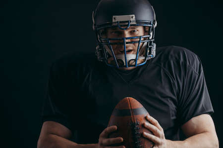 Sport concept american football sportsman player in black sports outfit on black background with copy space sport concept