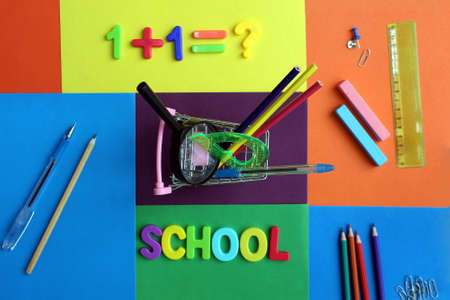 Shopping cart stands with stationery on the background of school supplies Stock Photo