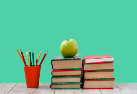 Books textbook in colorful covers on a green background back to school distance home education quarantine concept of stay home