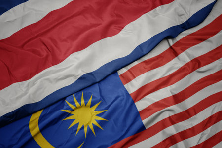 Waving colorful flag of malaysia and national flag of costa rica macro Stock Photo