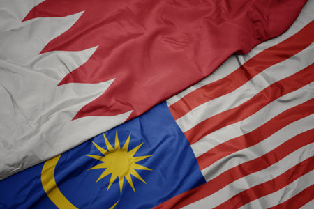 Waving colorful flag of malaysia and national flag of bahrain macro