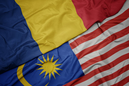 Waving colorful flag of malaysia and national flag of romania macro Stock Photo