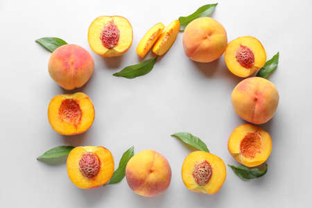 Frame made of ripe peaches on light background