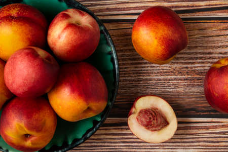 Red and yellow peaches in a green platter Stock Photo