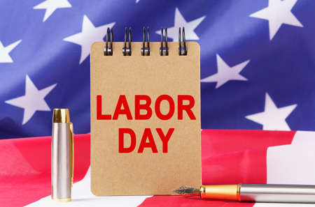 Usa holidays against the background of the us flag lies cardboard with the inscription labor day Stock Photo