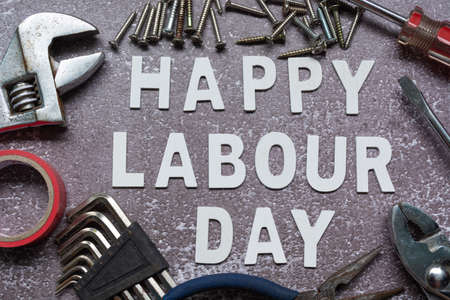 Happy labor day text with repair equipment and many handy tools on grunge grey concrete background