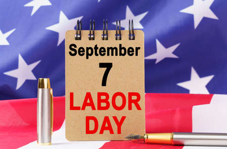 Usa holidays against the background of the us flag lies cardboard with the inscription labor day