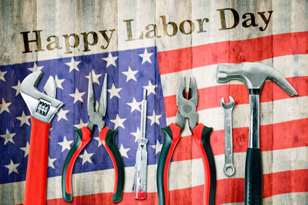 Labor day concept top view of handy tools with happy labor day text on american flag table background