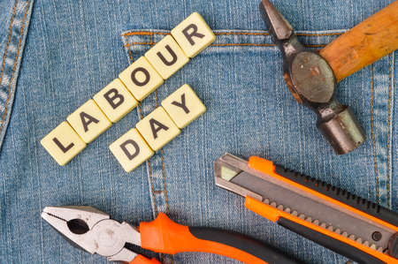 Square letters with text labour day with hammer plier and knife Stock Photo