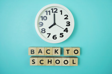 Back to school with clock on blue background