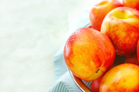 Sweet ripe nectarines in colander on table closeup