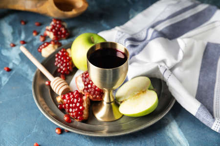 Sacramental goblet with wine apple and pomegranate on color background rosh hashanah jewish new year celebration