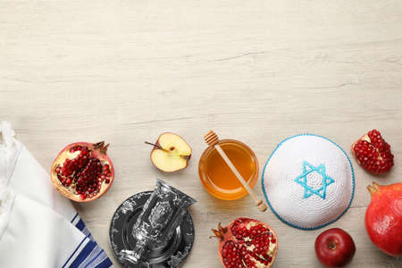 Flat lay composition with rosh hashanah holiday attributes on white wooden table space for text