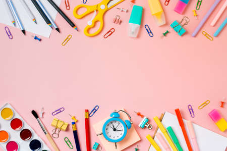 Creative student desk with school supplies and copy space in center top view or flat lay trendy back to school flat lay on pink background