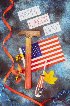 Creating banner with inscription happy labor day american flag hammer screwdriver and autumn leaves on a blue background labor day is america and canada traditional holiday